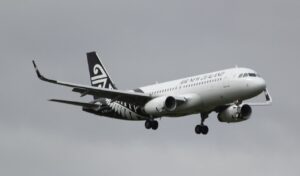Air New Zealand plane in flight against a cloudy sky.